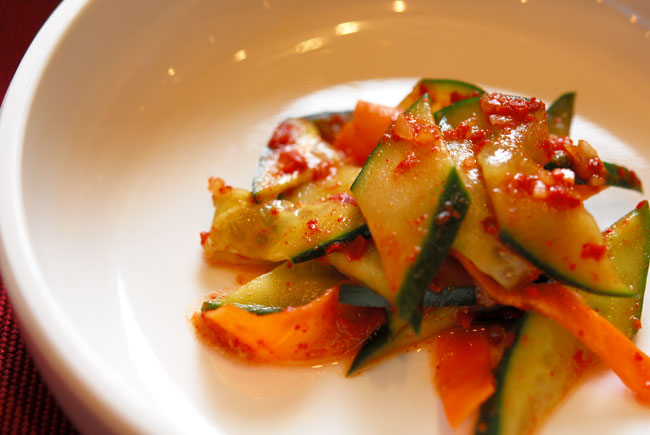 Korean oi-muchim cucumber salad with chili pepper and green onion, another illustrative serving