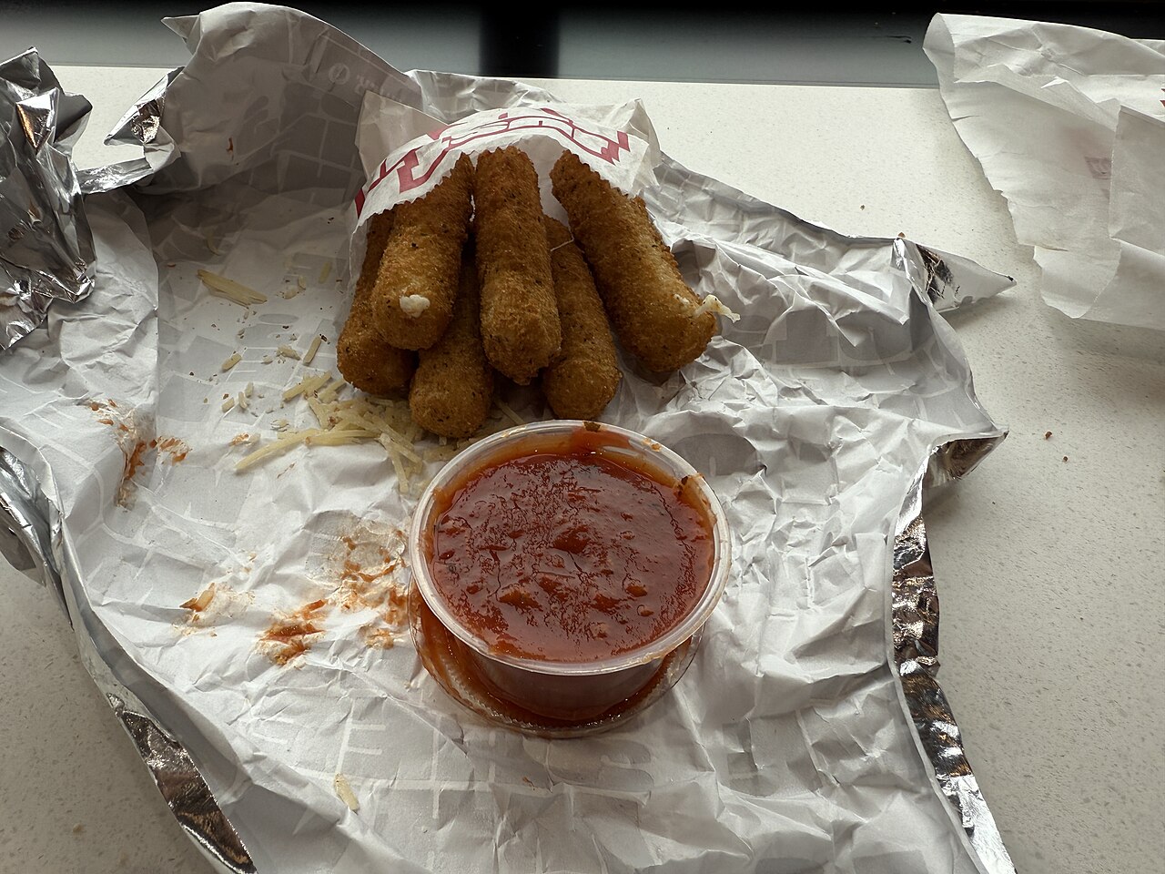 Commercial mozzarella sticks served with marinara sauce; illustrative serving example only