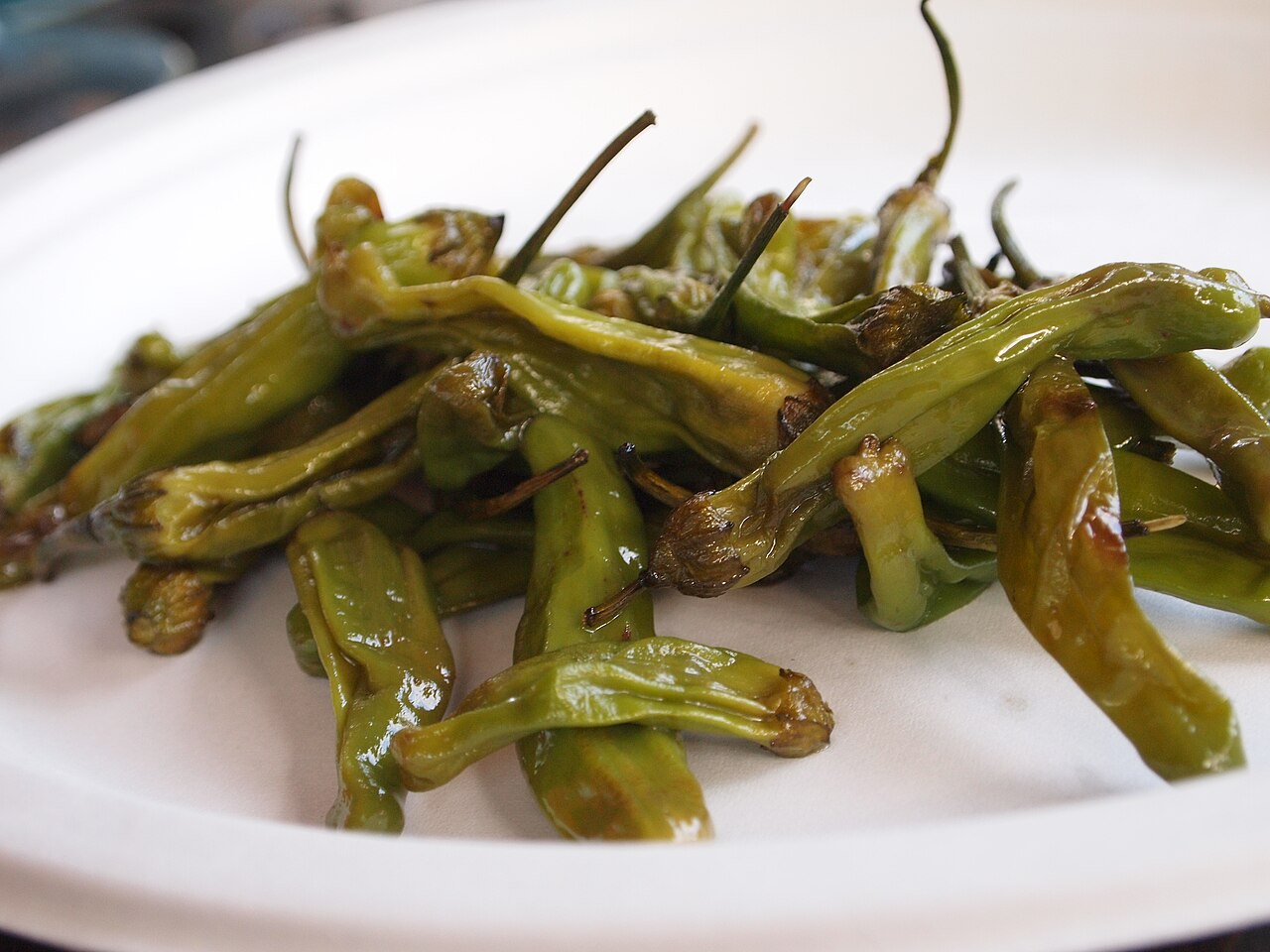 Fresh shishito peppers before cooking, an illustrative ingredient photo not a photo of blistered peppers